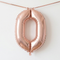 Rose-gold number 0 balloon hung from matching ribbon against a softly lit white wall