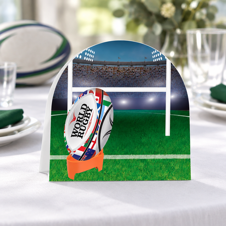 Rugby table centrepiece close-up on a white tablecloth with subtle rugby-party styling, in square format