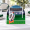 Rugby table centrepiece close-up on a white tablecloth with subtle rugby-party styling, in square format