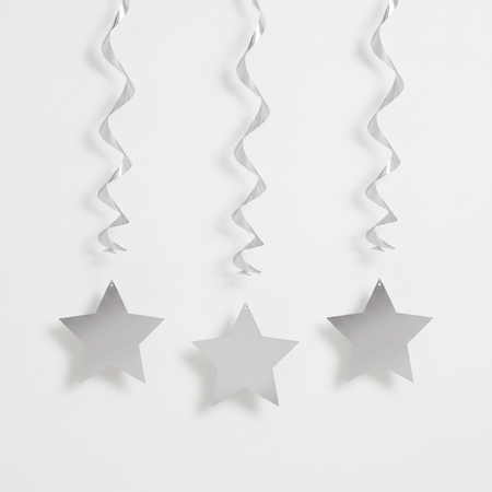 Silver hanging star swirls against a white wall