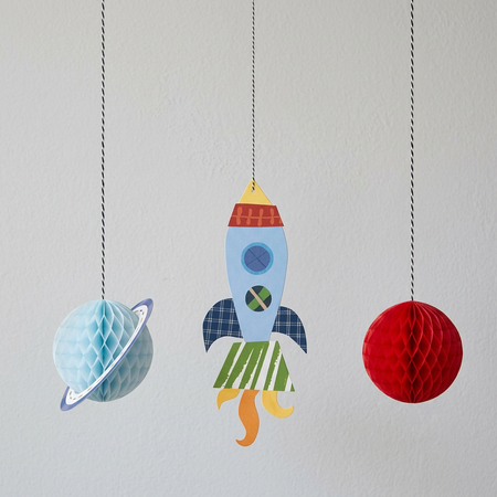Space decorations against a light grey wall with soft light and shade, in square format