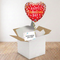 Square red Valentine's balloon gift using the previous image’s wooden floor and white wall background reference