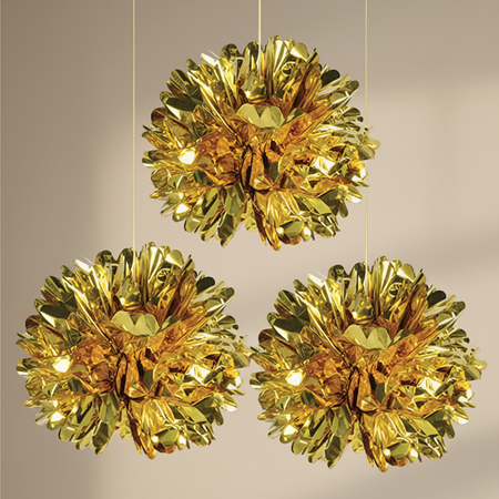 Three gold hanging decorations against a neutral background