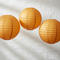 Three Orange Paper Lanterns Filling Square Frame on White Wall