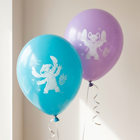 Turquoise and purple balloons floating with silver curling ribbon against a softly lit neutral wall, close up in square format