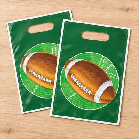 Two American football gift bags fanned out on a wooden table, viewed from above in square format