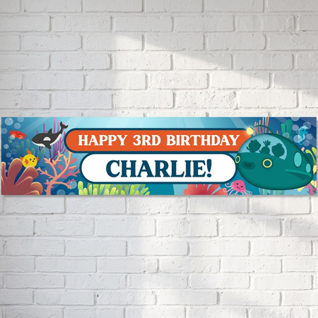 Underwater birthday banner on a white brick wall with soft light and shade, in square format