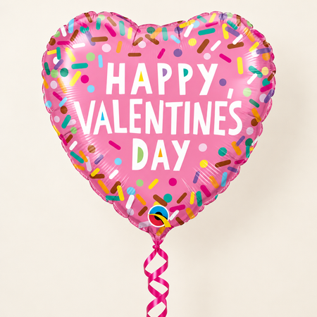 Valentine’s sprinkles balloon floating with bright pink curling ribbon against a cream background with soft light and shade, in square format