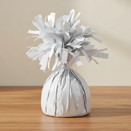 White balloon weight on a wood table with a neutral background