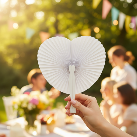 White Paper Heart Fan Being Used Outdoors