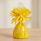 Yellow balloon weight close up on the matching wooden table with a neutral background and soft lighting, in square format